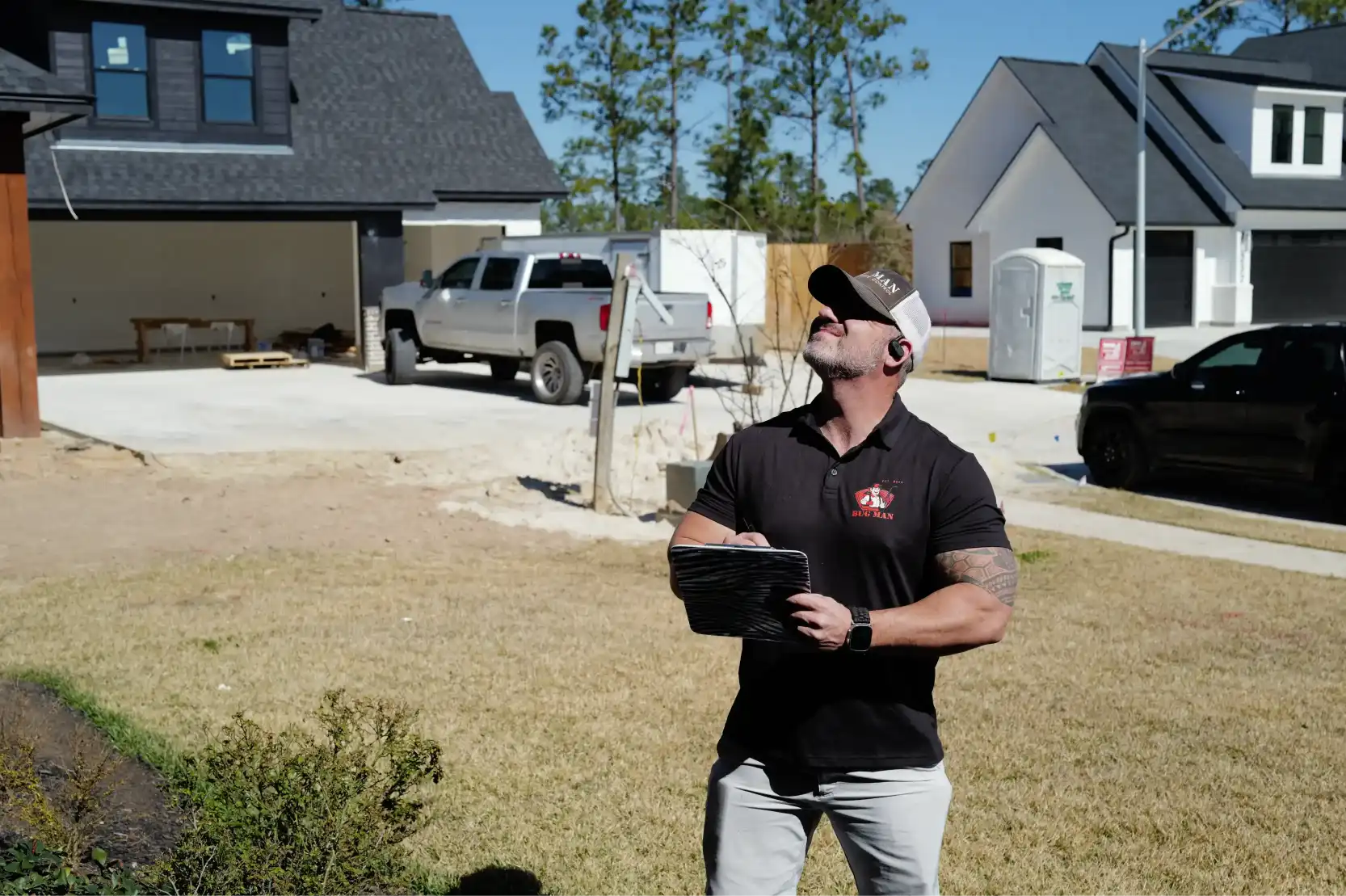 BugMan professional assessing exterior conditions with a tablet in Lumberton