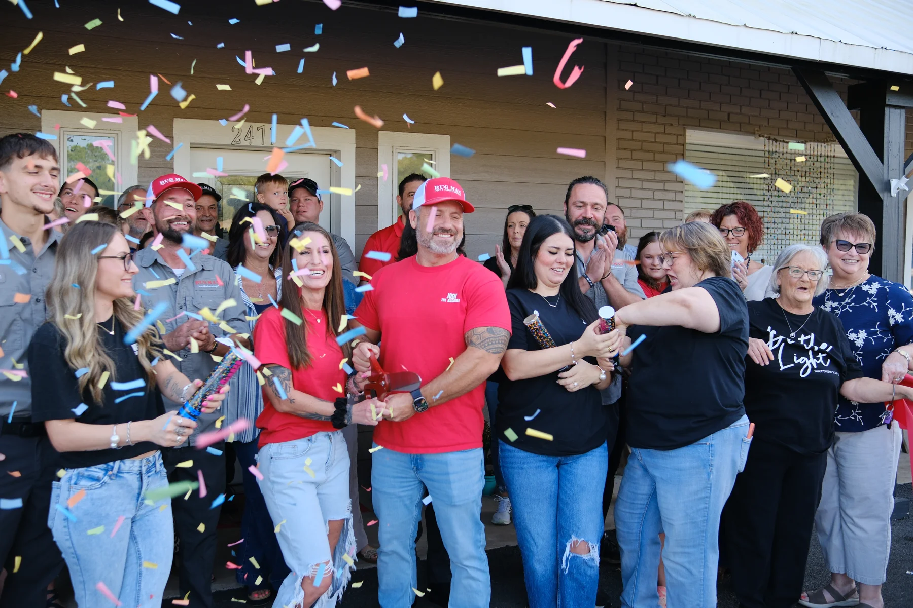 Confetti falls around Josh Culver and guests at BugMan’s ribbon cutting in Lumberton.