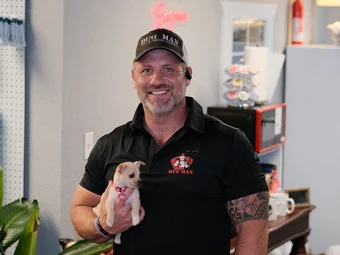 Josh Culver – Owner of Bug Man TX Pest Control Josh Culver holding a small dog at the BugMan office